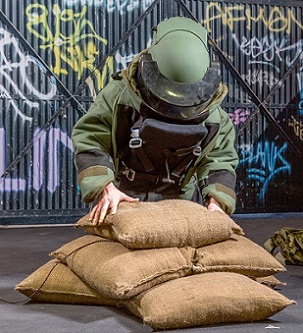 Un soldado poniendo sacos de arena sin arena BlastSax alrededor de un artefacto explosivo improvisado