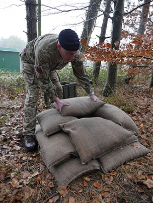 Soldier placing BlastSax sandless sandbags around an improvised explosive device during an exercise