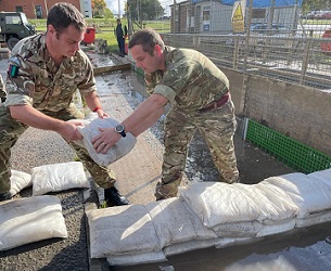 Soldiers building a wall of FloodSax alternative sandbags to prevent flooding