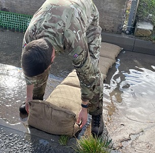 Soldier deploying BlastSax alternative sandbags to stop floodwater