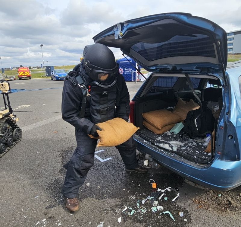 Bomb disposal officer lifting a BlastSax alternative sandbag out of a car after suspicious package was destroyed by a controlled explosion 2.jpg